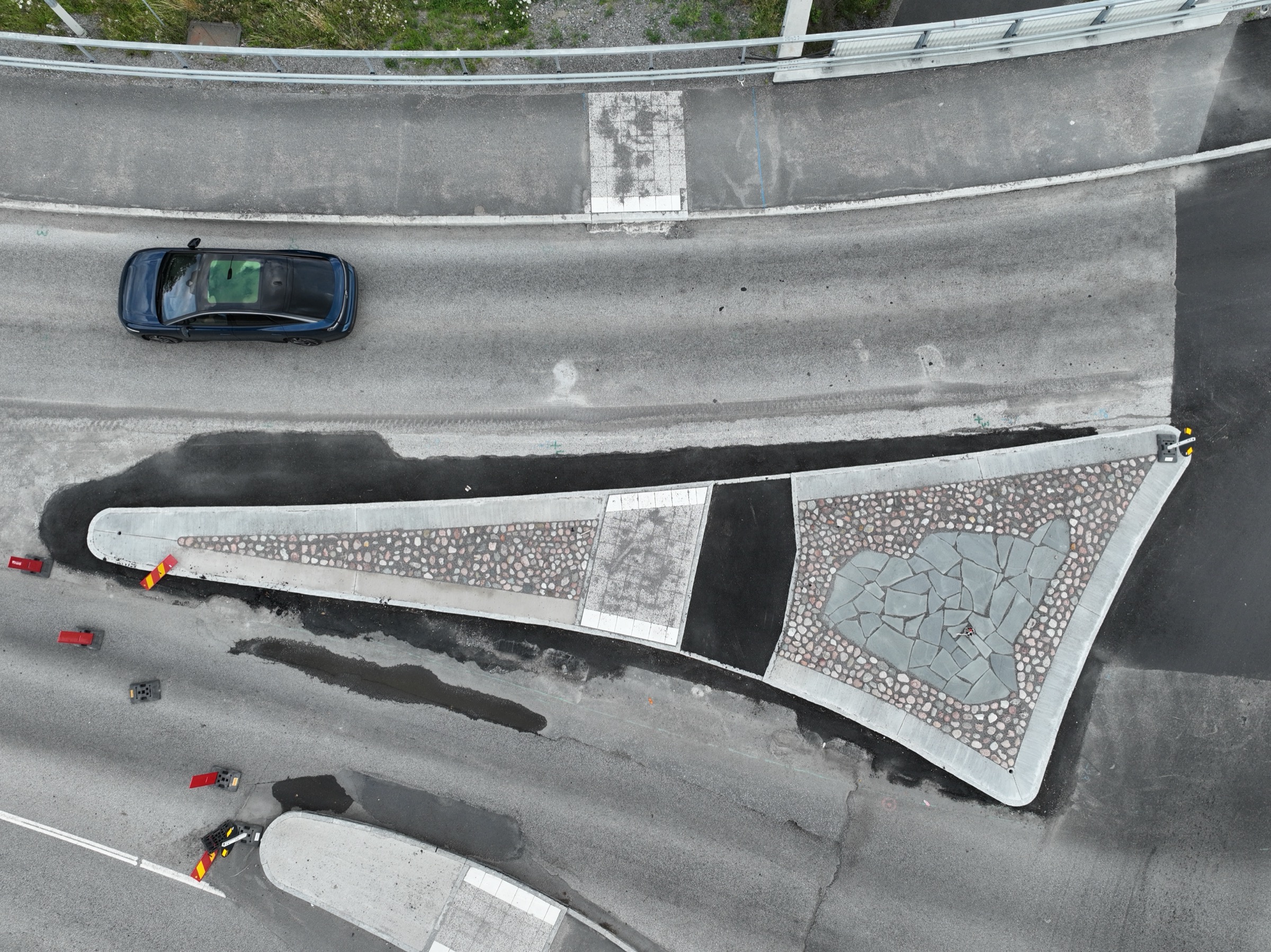 Detaljbild av stenläggning i rondell — natursten och betongplattor i mosaikmönster